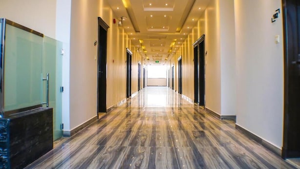 A long, well-lit corridor with a polished floor, leading to a bright exit. - Malath Raqi (Riyadh)