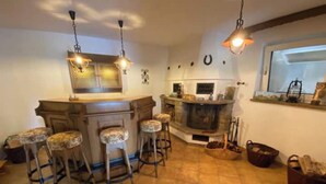Una cocina con barra, chimenea y luces colgantes.