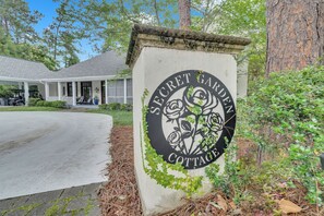 A sign for 'Secret Garden Cottage' with a circular emblem featuring roses. - Heart of Historic Pinehurst, Golf, Saltwater Pool (Pinehurst)