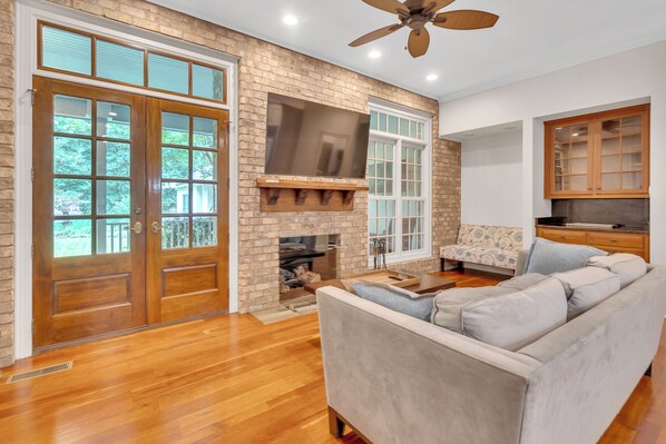 A spacious living room with a fireplace, a large TV, and a sofa.