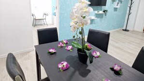 A dining table with a black tablecloth, surrounded by black chairs, and decorated with white and purple flowers. - 301, 2 bedrooms,close Playa las Americas&free wifi (Playa de la Américas)