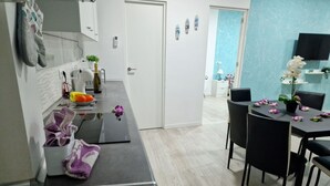 A modern kitchen with a built-in oven, a sink, and a dining area with a table and chairs. There is a door leading to another room. - 301, 2 bedrooms,close Playa las Americas&free wifi (Playa de la Américas)
