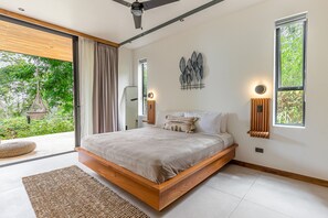 Relax in a serene space with a large bed and unique wall art, set against a clean and uncluttered backdrop.