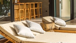 Un área de estar moderna con sofá cama, cojines y una cesta tejida.
