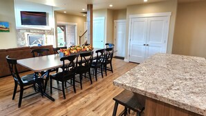 A spacious kitchen with a granite countertop, wooden flooring, and a dining area with a table and chairs. - New home in the heart of Alpine! (Alpine)
