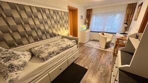 Une chambre à coucher de taille réduite, comprenant un lit, un petit bureau et une chaise.