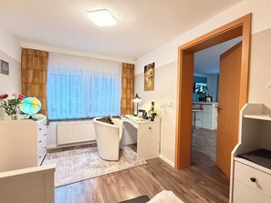 A well-lit room with a desk, chair, and a globe on a dresser. - Modern 4-star apartment - stylish comfort, relaxation for people and dogs! (Weißenfels)
