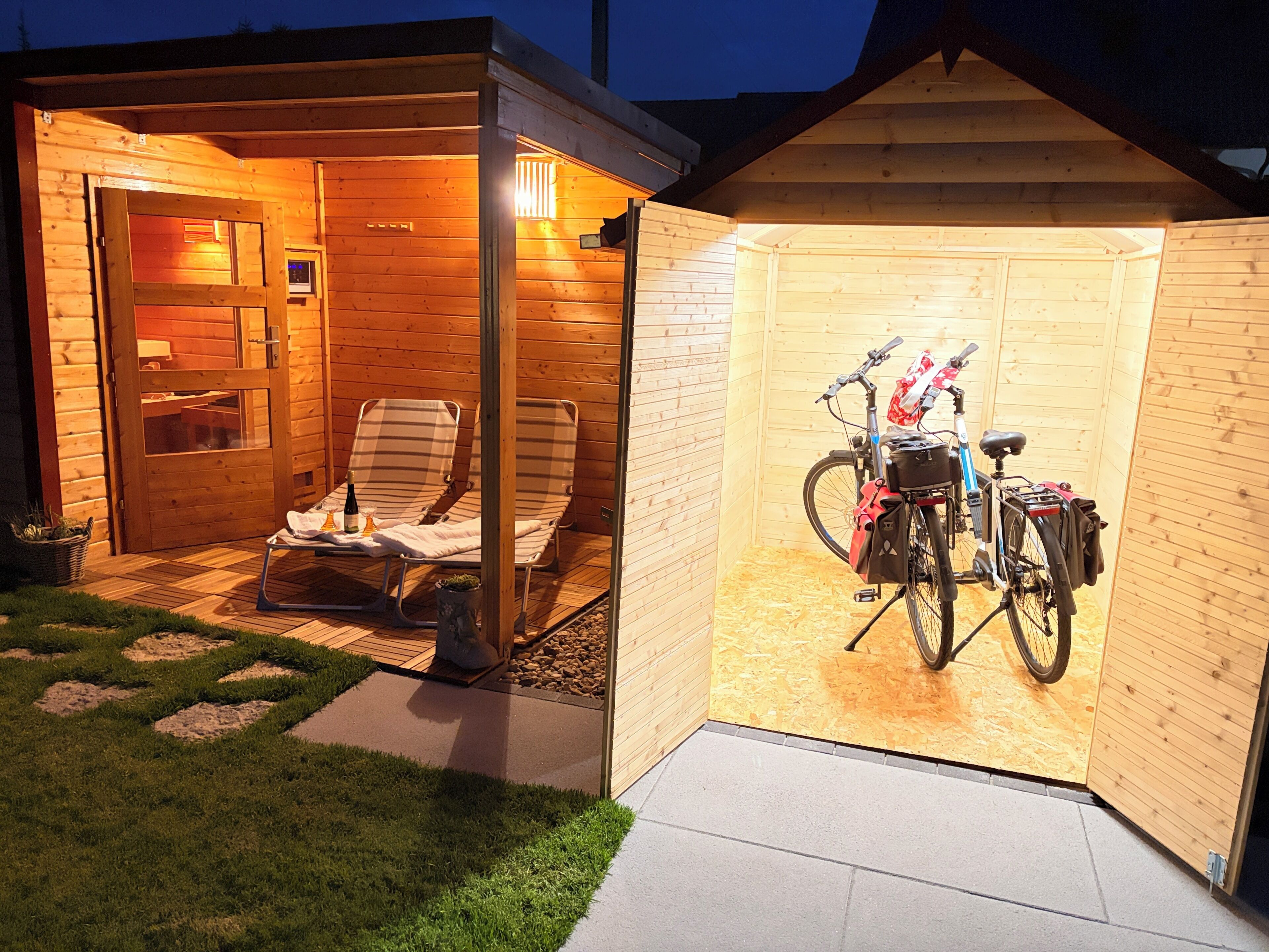Una cabaña de madera con un porche cubierto, una bicicleta y mobiliario para exteriores.