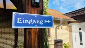 Un panneau de signalisation indiquant la direction à suivre vers la droite, avec le mot « Eingang » inscrit dessus.