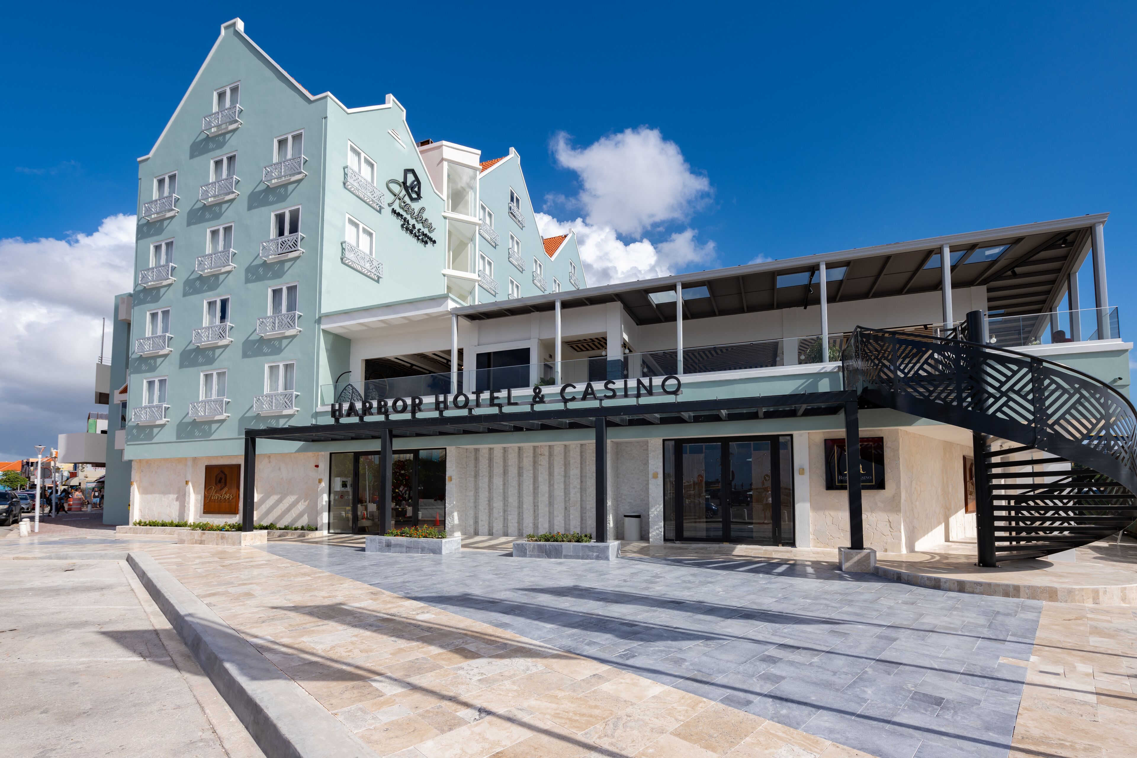 Un hôtel doté d’une façade moderne, de nombreux balcons et d’une entrée imposante avec une allée couverte.