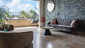 Un área de descanso moderna con sofá, una mesita redonda y un sillón colgante.