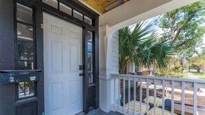 A porch with a white railing, a black door, and a mailbox. - Cozy Springfield Abode - AC, Wifi, WD (Jacksonville)