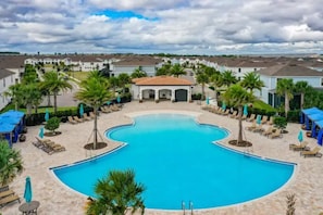 Relax by the heart-shaped pool surrounded by lounge chairs and palm trees.