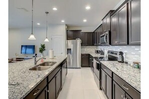 Enjoy cooking in this well-equipped kitchen with a refrigerator, microwave, and dishwasher.