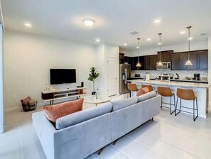 Relax in this spacious living area with a large sofa, flat-screen TV, and a stylish coffee table.