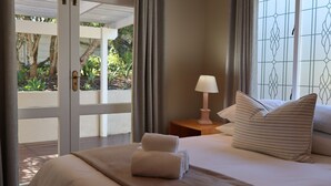 Une chambre d’hôtel avec un lit, une lampe de chevet et une vue sur la verdure.