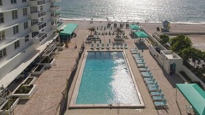 Un hôtel doté d’une piscine, offrant une vue sur la plage et comprenant plusieurs étages.