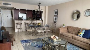 Un salon comprenant un canapé, une table basse et un coin repas avec des chaises et une table.
