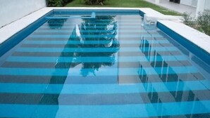 A rectangular swimming pool with a clear blue water surface and a tiled deck. - Hotel Noor (Chetumal)