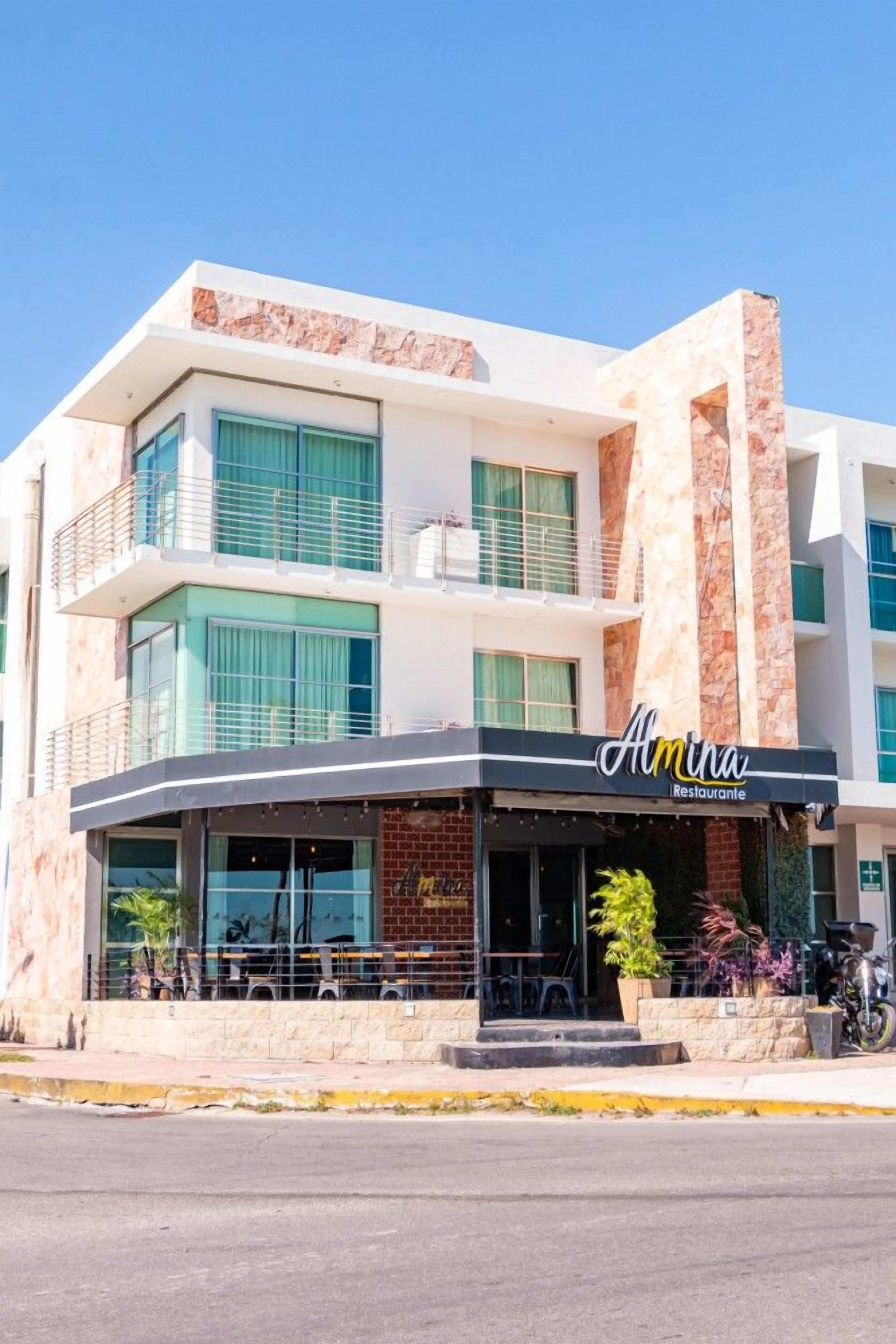 A two-story building with a restaurant named 'Almina Restaurante' on the ground floor.