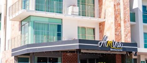 A two-story building with a restaurant named 'Almina Restaurante' on the ground floor.