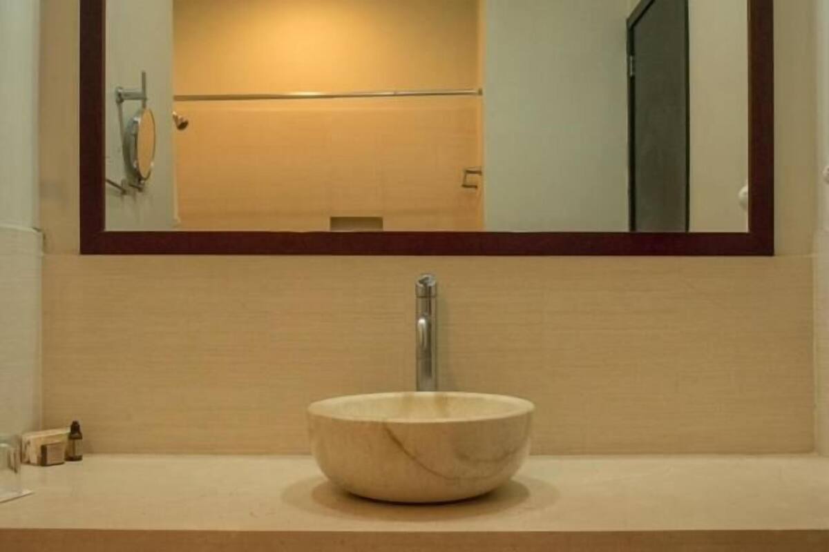 Une salle de bain avec un lavabo en marbre, un miroir et un porte-serviettes.