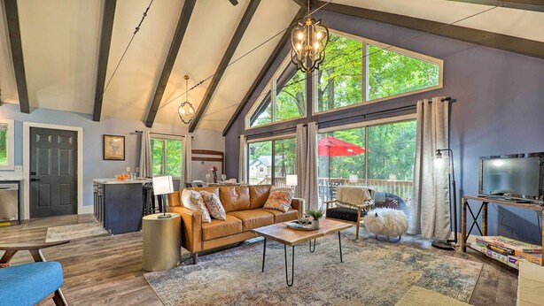A spacious living room with a large window, a fireplace, and a cozy seating area. - Pet-Friendly Stanwood Sanctuary w/ Fire Pit! (Stanwood)