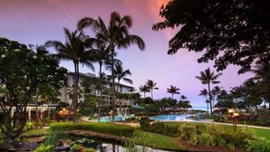 Ein Resort mit Pool, Palmen und einem angelegten Garten.