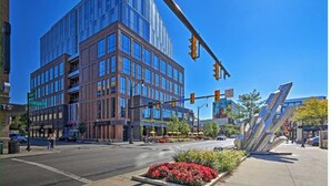 A modern building with large windows and a street intersection.