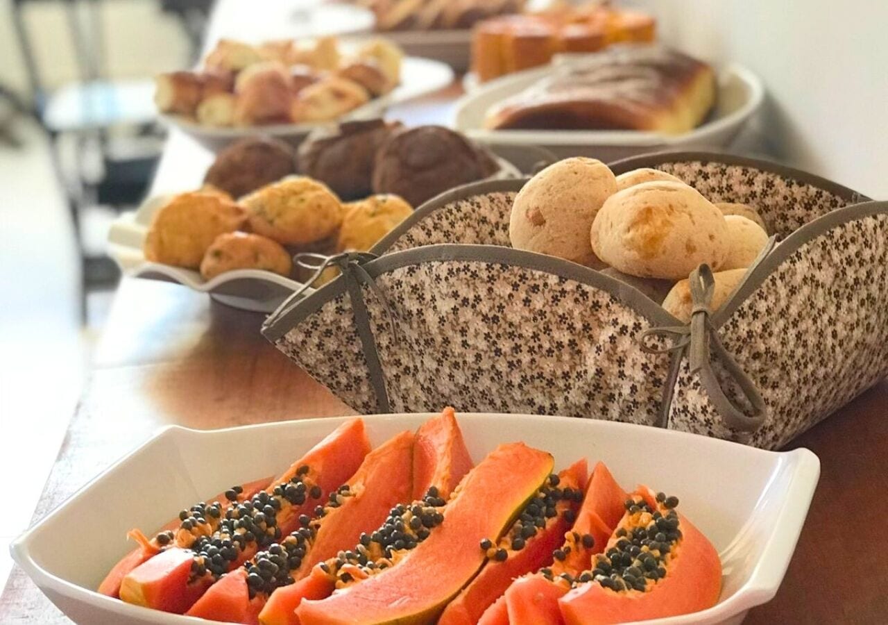 A buffet table with various food items including sliced papaya and bread.