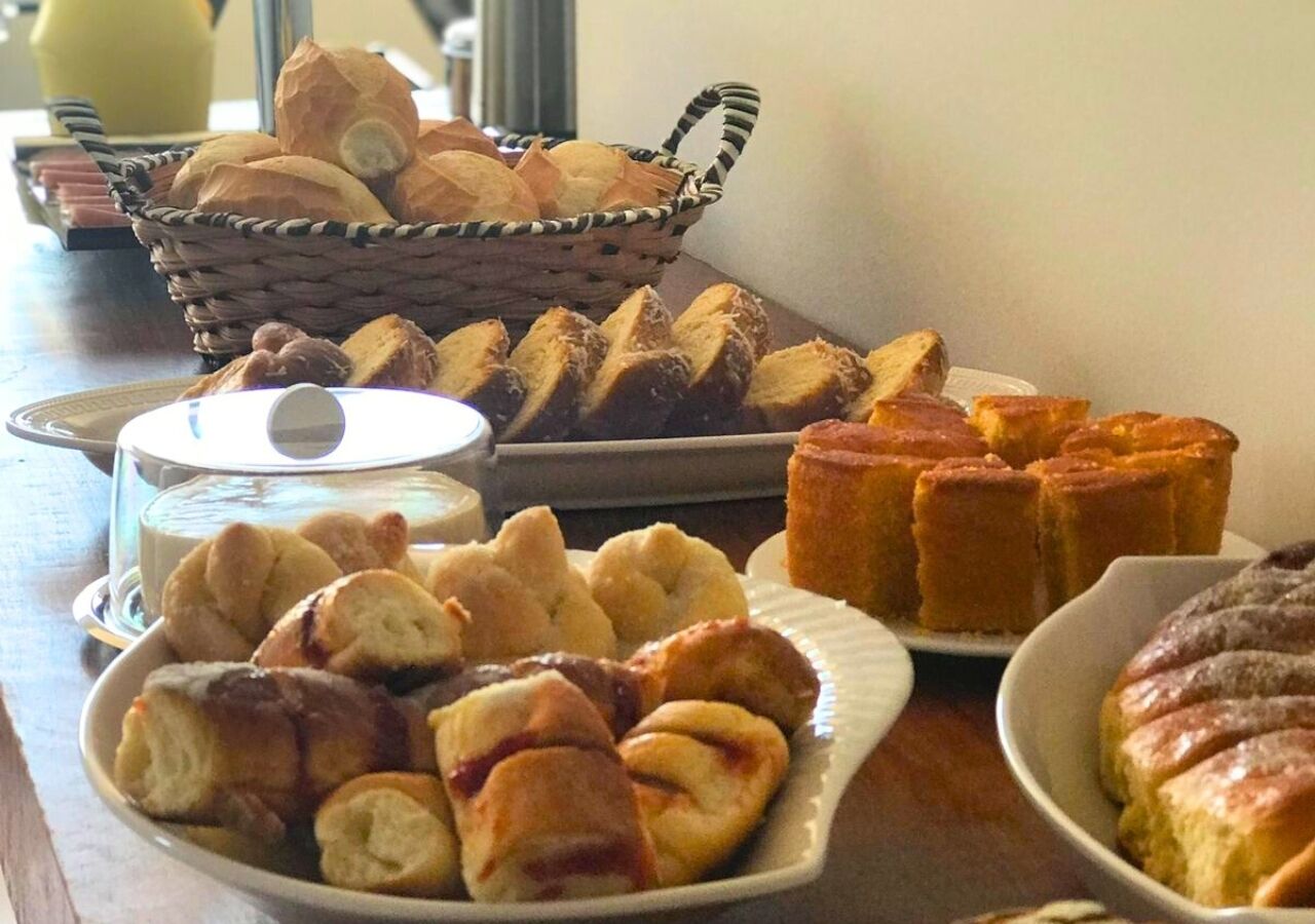 A table with various baked goods including bread, rolls, and pastries.
