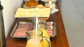 A buffet table with various food items and beverages.
