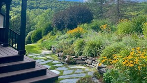 A covered outdoor area with a stone pathway leading to a wooden deck. - Spacious Villa with Beautiful Views and Great Energy!!! (Stowe)