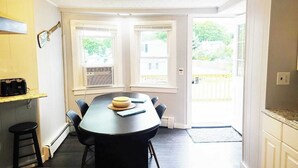 Un espace repas comprenant une table, des chaises et un comptoir de cuisine.