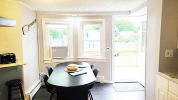 A dining area with a table, chairs, and a kitchen counter.