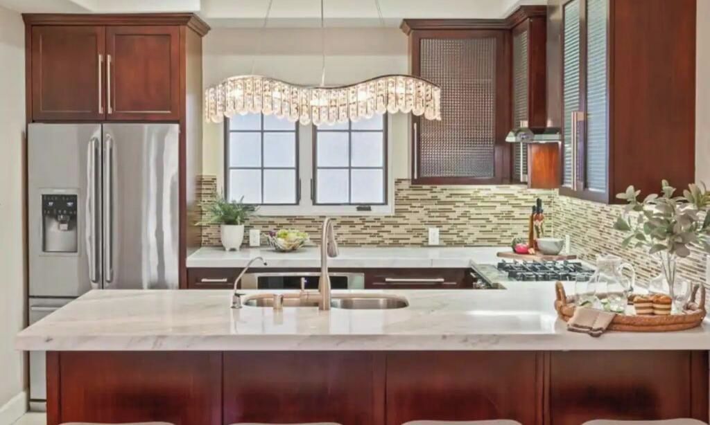 A modern kitchen with a central island, stainless steel appliances, and wooden cabinetry.