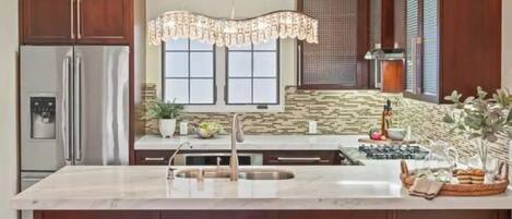 A modern kitchen with a central island, stainless steel appliances, and wooden cabinetry.