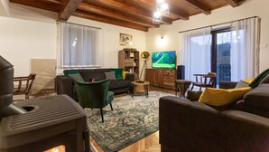 A cozy living room with a fireplace, a sofa, a coffee table, and a TV. - Ideal oasis for a vacation surrounded with forest (Kupa, Brod na Kupi)