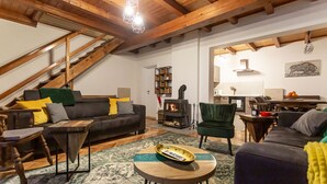 A cozy living room with a fireplace, wooden beams, a staircase, and a dining area. - Ideal oasis for a vacation surrounded with forest (Kupa, Brod na Kupi)