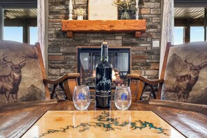 A table with a bottle of wine, two glasses, and a decorative table runner. - Private Putting Green Retreat with Firepit, Hot Tub, Free Tickets, Views & Community Indoor Pool (Branson)