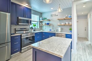 A modern kitchen with dark blue cabinets, stainless steel appliances, and a marble countertop. - Immaculate Long Beach Apt w/ Gorgeous Kitchen (Long Beach)