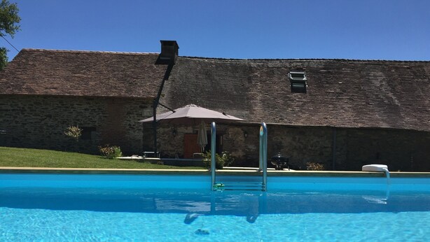 A clear blue pool with a stone building in the background. - Beautiful luxury restored gîte with private solar heated pool. (St. Paul la Roche)
