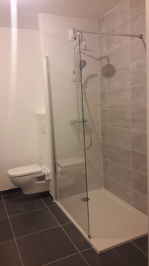 Een douche, handdoeken, zeep, shampoo