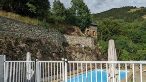 A pool area with a stone wall, wooden deck, and a view of a hillside. - Maître de Cabestany - 3 en-suite bedrooms + 1 mezzanine (Llo)