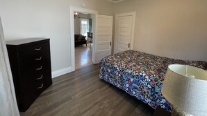 Une chambre à coucher avec un lit, une commode et un ventilateur de plafond.