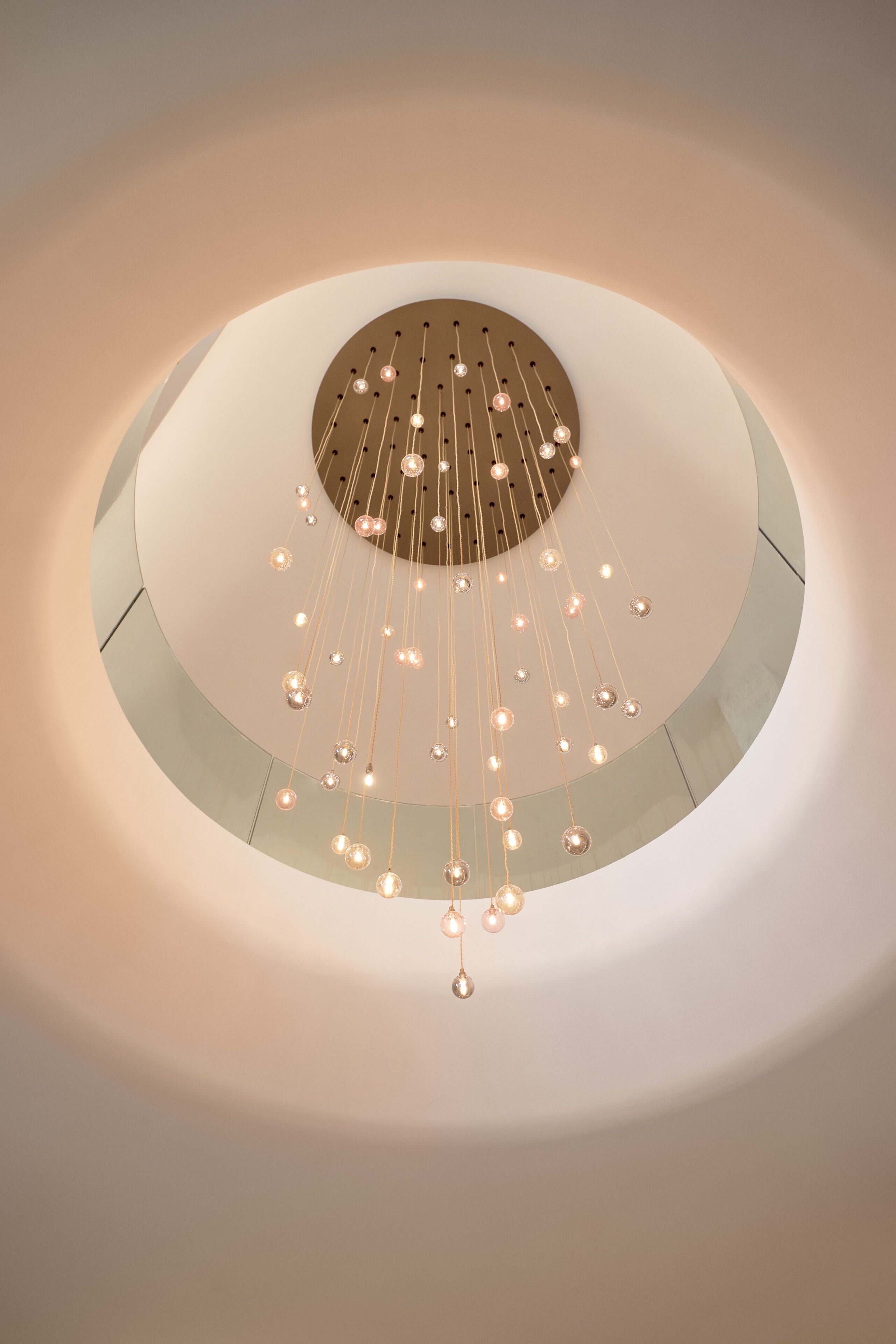 A circular ceiling with hanging light fixtures and a central circular design.