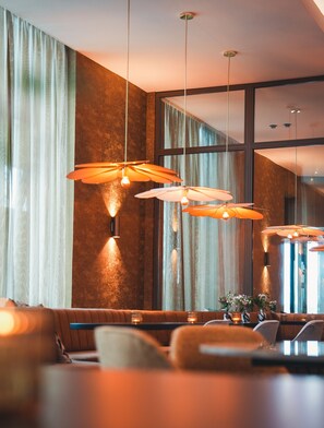 A modern interior with a large window, a sofa, and pendant lighting. - Van der Valk Hotel Delft A4 (Den Hoorn)