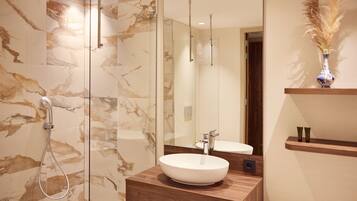 A modern bathroom with a glass-enclosed shower, a wooden vanity with a white sink, and a mirror above the sink.