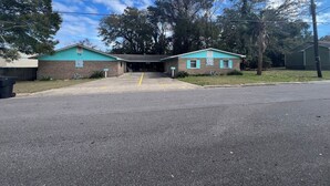 A two-story building with a parking lot in front. - Close to Downtown, Restaurants, Markets , Events ,Beaches and Naval Base! (Pensacola)