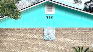 A turquoise building with the number 716, a brick wall, and a decorative metal plate. - Close to Downtown, Restaurants, Markets , Events ,Beaches and Naval Base! (Pensacola)